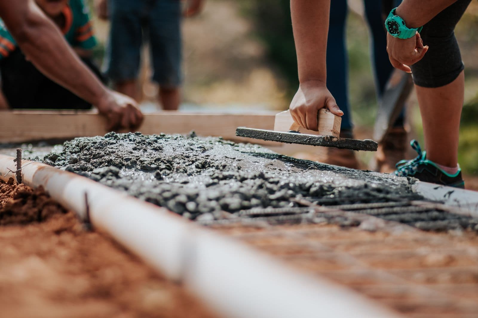 Trabajadores de construcción usando equipos alquilados en una obra