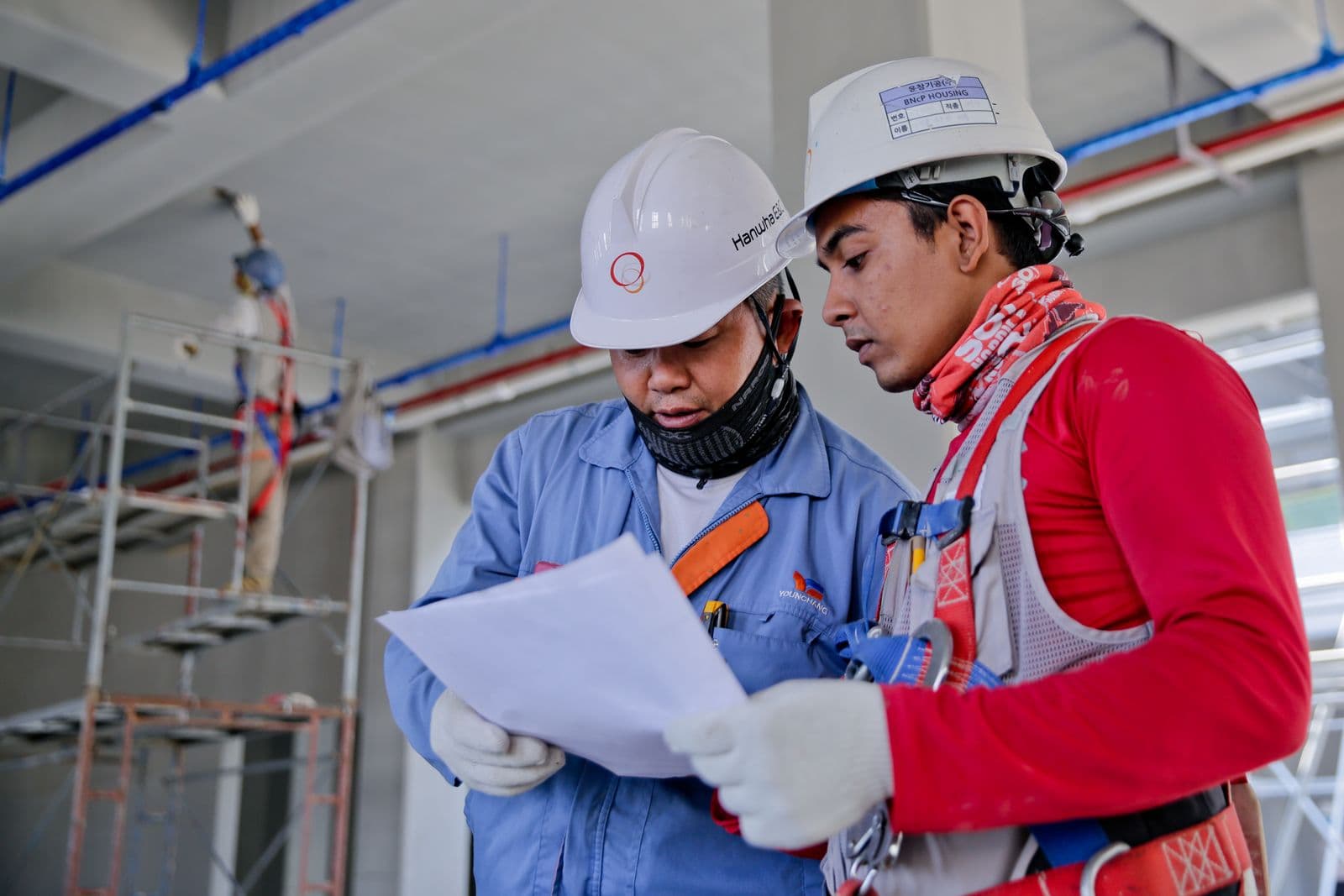 Dos trabajadores de construcción revisando una cotización de alquiler de equipos en obra